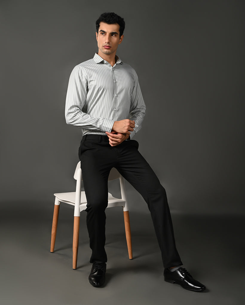 Man wearing a light gray striped shirt against a dark gray background