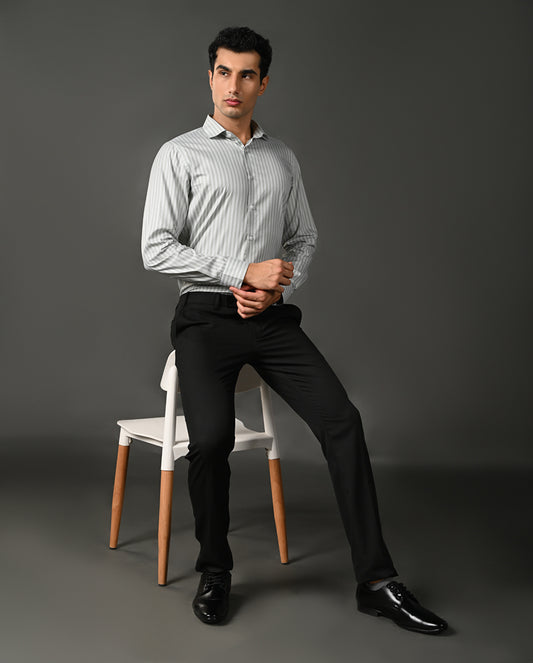 Man wearing a light gray striped shirt against a dark gray background