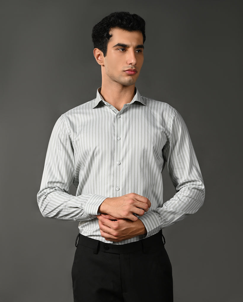 Man wearing a light gray striped shirt against a dark gray background