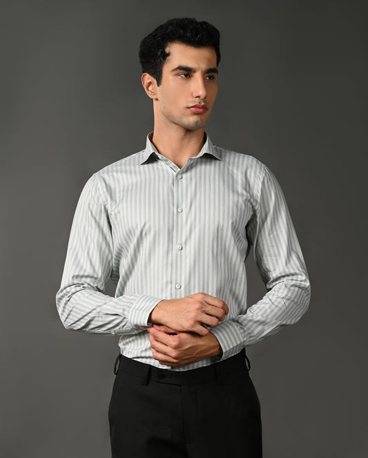 Man wearing a light gray striped shirt against a dark gray background