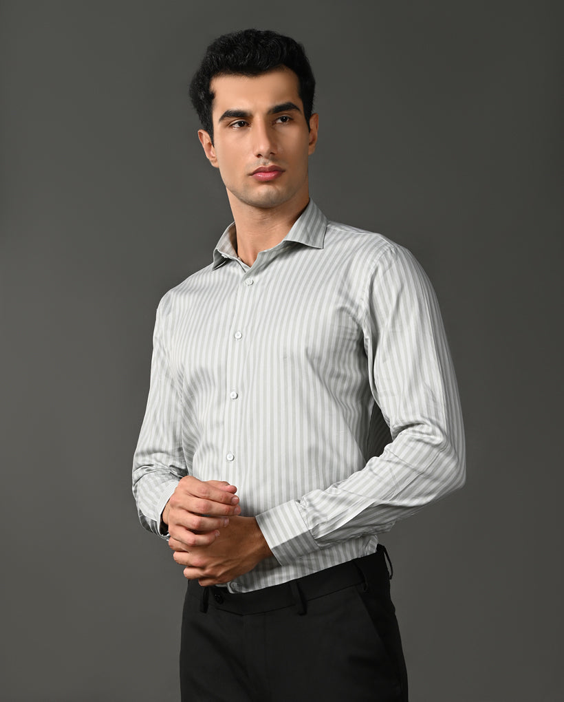 Man wearing a light gray striped shirt against a dark gray background