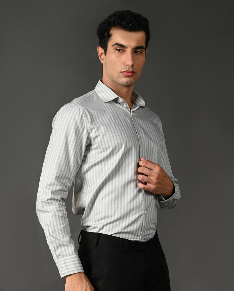 Man wearing a light gray striped shirt against a dark gray background