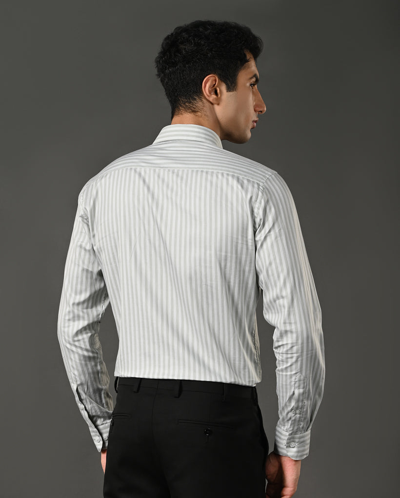 Man wearing a light gray striped shirt against a dark gray background