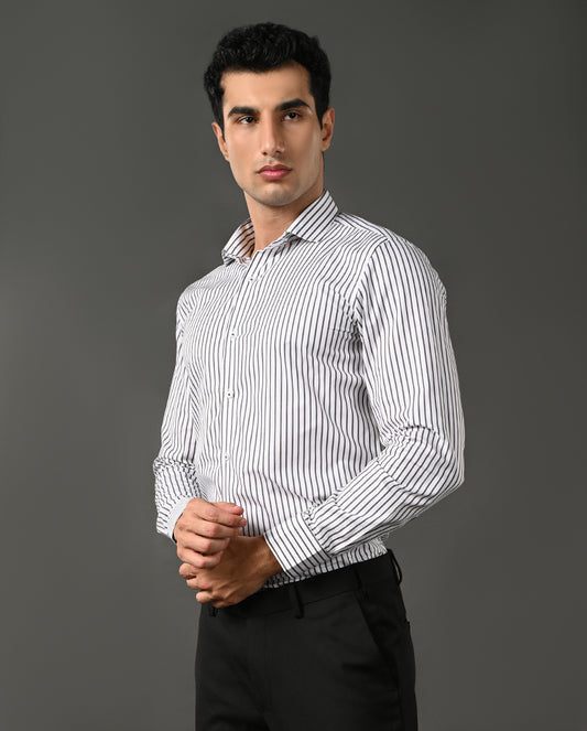 Man wearing a white shirt with black stripes against a gray background