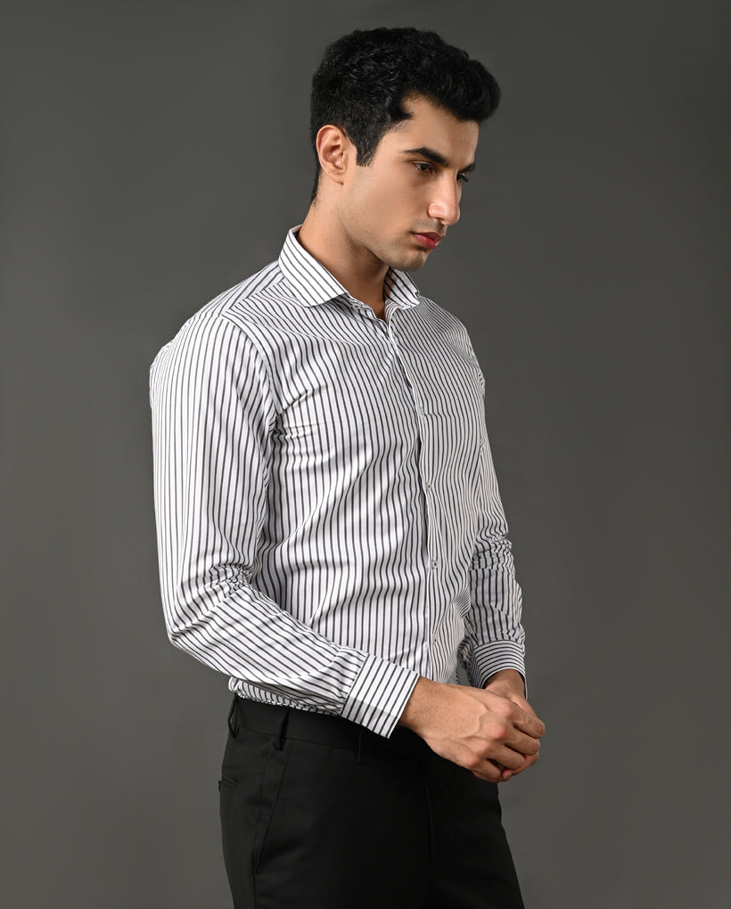 Man wearing a white shirt with black stripes against a gray background