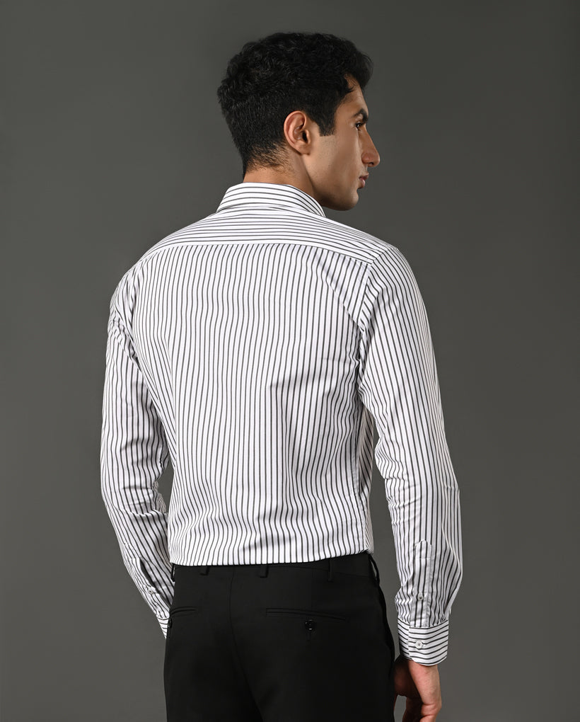 Man wearing a white shirt with black vertical stripes against a gray background