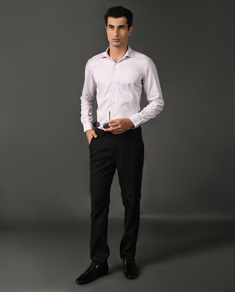 Man wearing a light purple dress shirt and black pants against a gray background