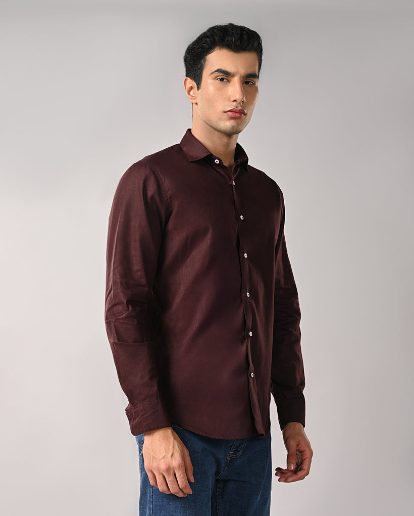 Man wearing a brown shirt against a gray background