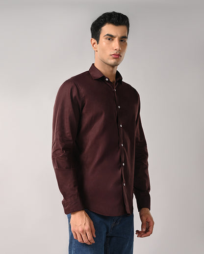Man wearing a brown shirt against a gray background