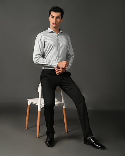 Man wearing a light gray striped shirt against a dark gray background