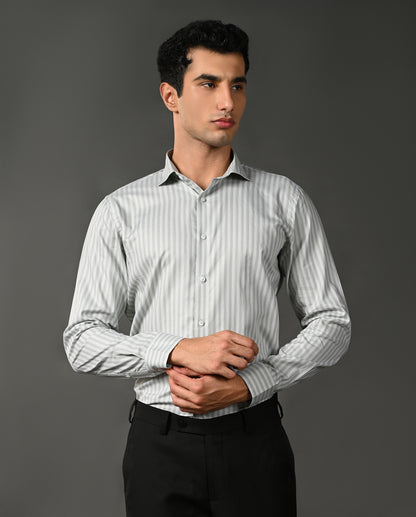 Man wearing a light gray striped shirt against a dark gray background