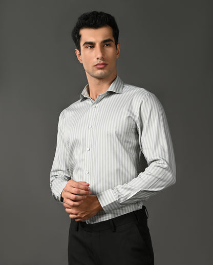 Man wearing a light gray striped shirt against a dark gray background