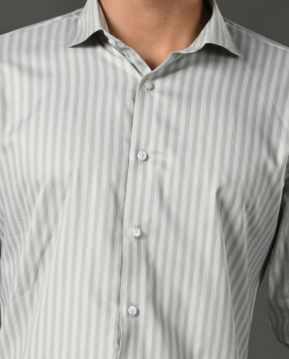 Man wearing a light gray striped shirt against a dark gray background
