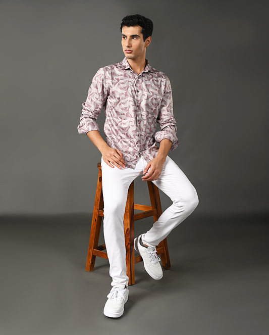 Man wearing a patterned shirt, white pants, and white sneakers on a gray background