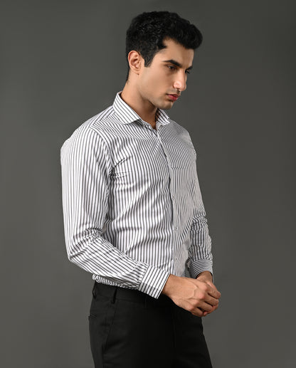 Man wearing a white shirt with black stripes against a gray background
