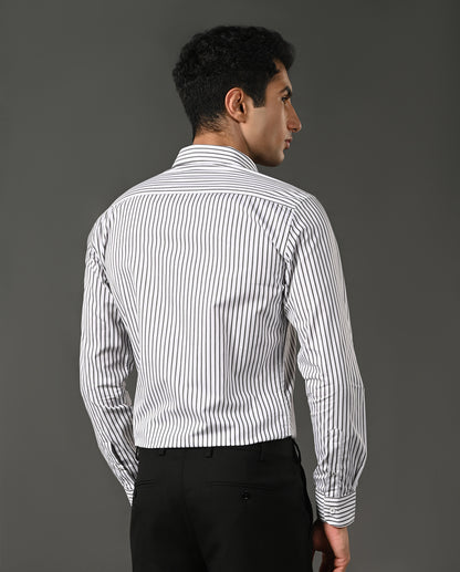Man wearing a white shirt with black vertical stripes against a gray background