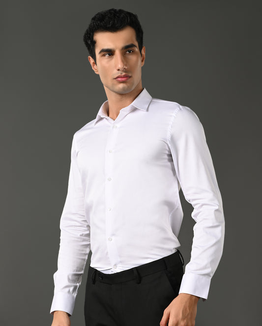 Man wearing a white dress shirt and black pants against a gray background