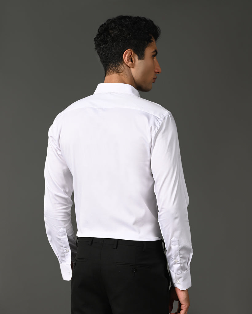 Man wearing a white dress shirt and black pants against a gray background