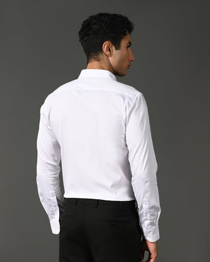 Man wearing a white dress shirt and black pants against a gray background
