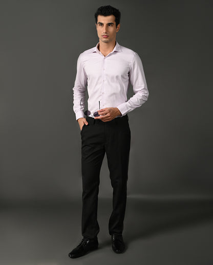Man wearing a light purple dress shirt and black pants against a gray background