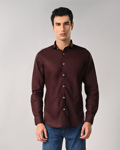 Man wearing a maroon shirt against a gray background